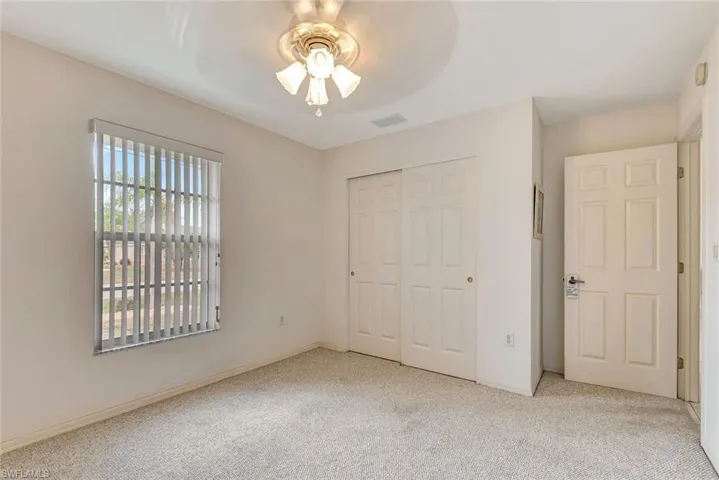 Unfurnished bedroom featuring light carpet, a closet, and ceiling fan
