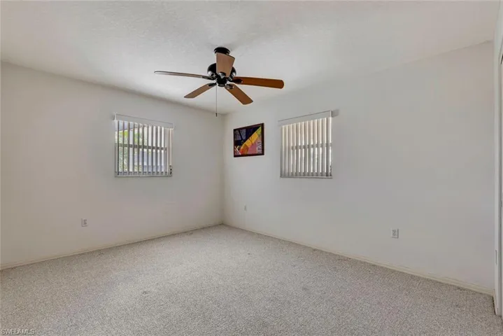 Carpeted spare room featuring a ceiling fan and a textured ceiling