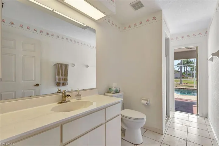 Bathroom with vanity, light tile patterned floors, and a textured ceiling