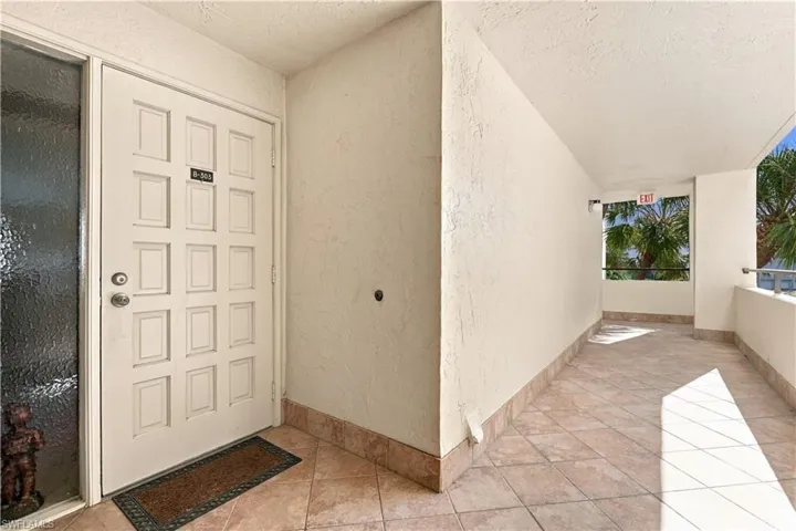 Entryway featuring a paneled door with textured glass sidelight, textured wall finish, and tile flooring