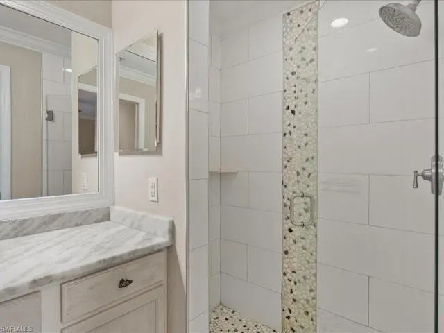 Full bathroom with crown molding, a stall shower, and vanity