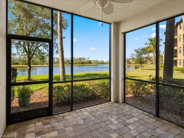 Unfurnished sunroom featuring ceiling fan and a water view