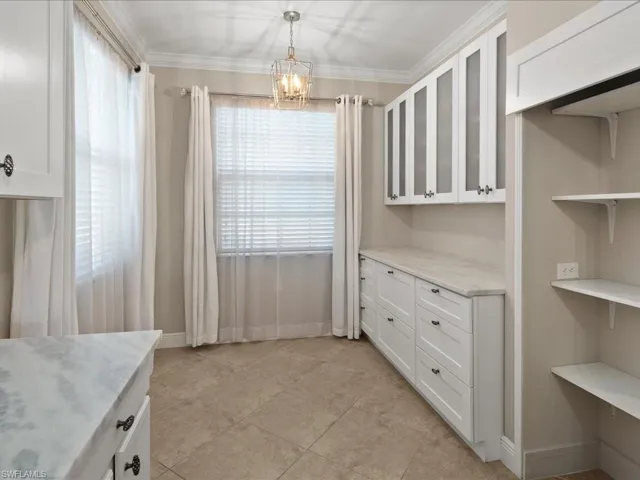 Unfurnished dining area featuring ornamental molding and a chandelier