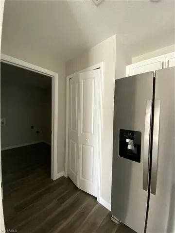 Corridor with dark wood-style flooring and a textured ceiling