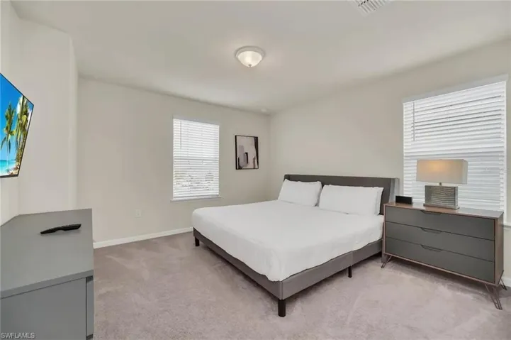 Bedroom featuring light colored carpet and baseboards