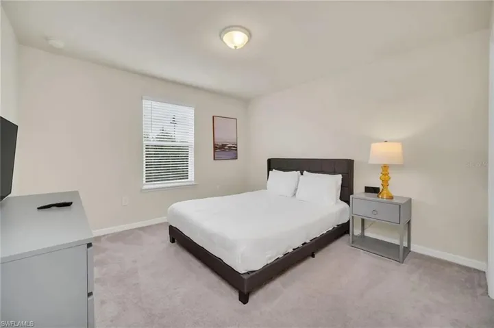 Bedroom with light carpet and baseboards