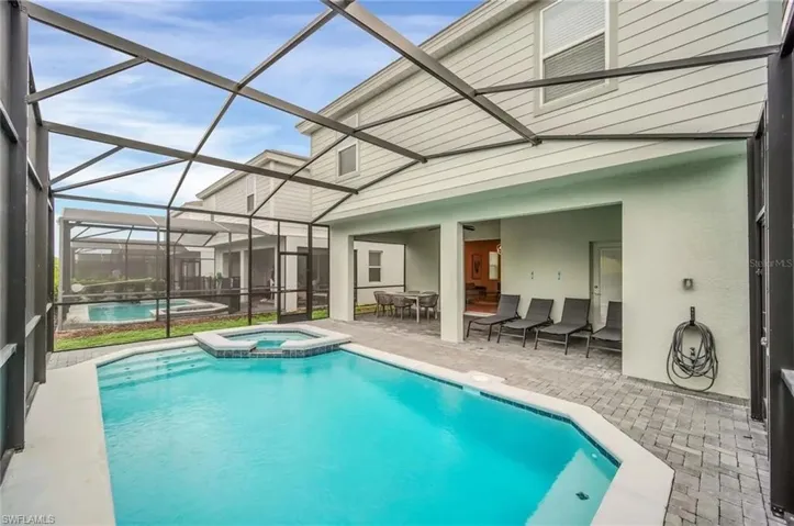 Integrated pool / hot tub featuring a sunroom, a patio area, and glass enclosure