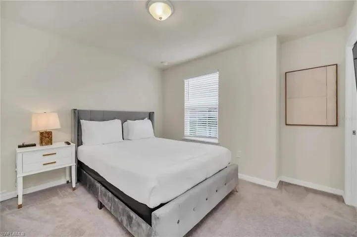 Bedroom featuring baseboards and light carpet