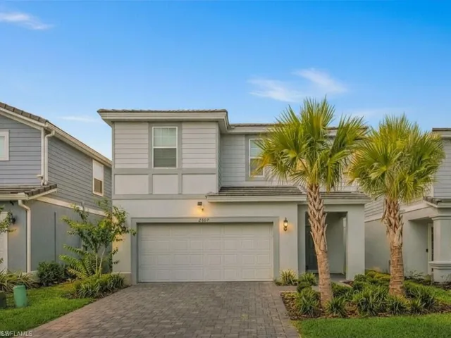 View of front facade featuring decorative driveway, a garage, and stucco siding