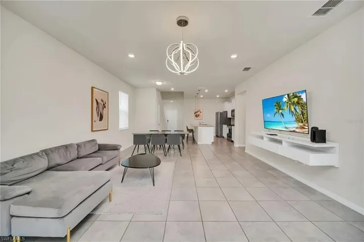 Living room with light tile patterned floors and hanging lights