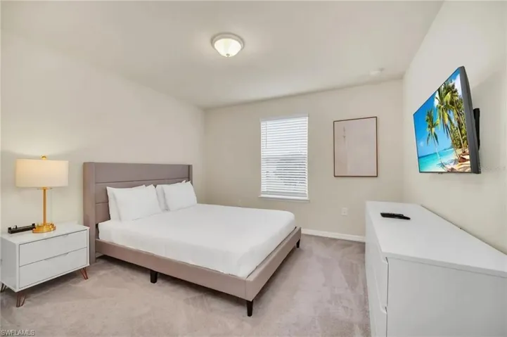 Bedroom featuring light colored carpet and baseboards