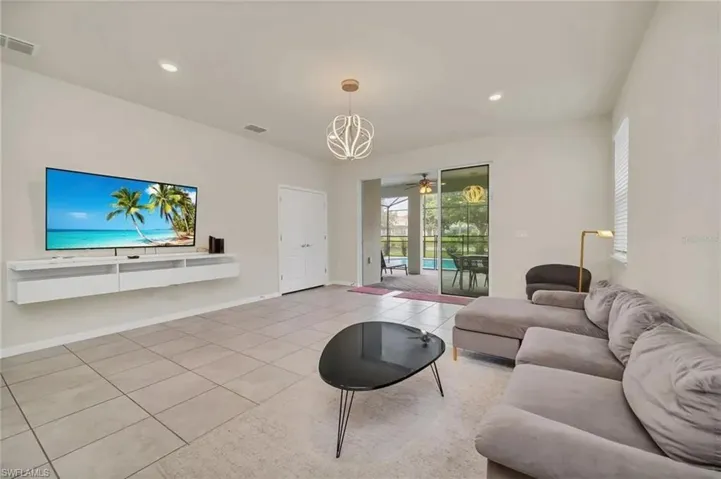 Living area featuring light tile patterned floors, recessed lighting, a ceiling fan, and a sunroom