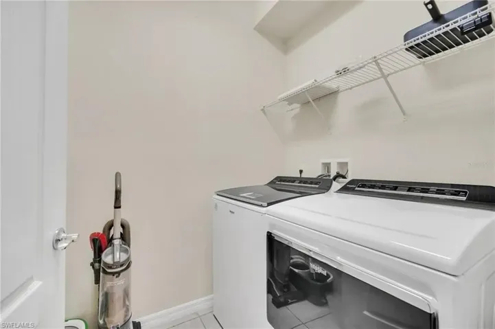Laundry room featuring separate washer and dryer and light tile patterned floors