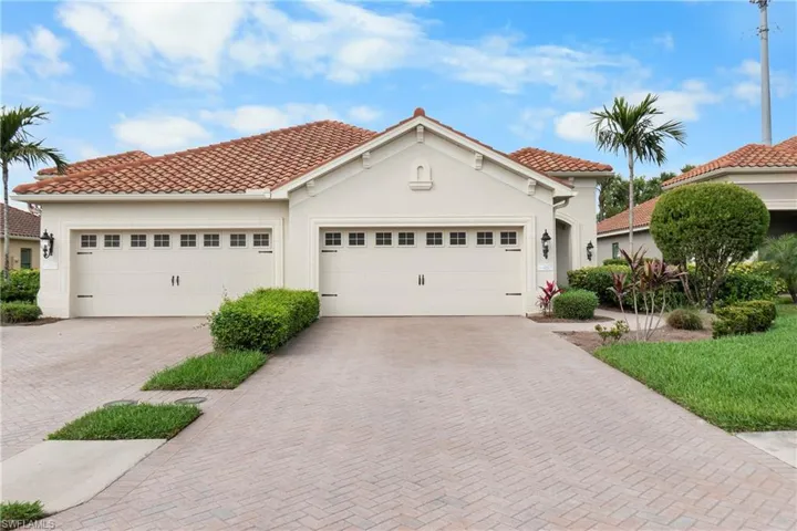 Front of home featuring a garage, a tiled roof, decorative driveway, and stucco siding