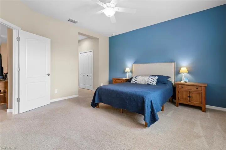 Bedroom with baseboards, visible vents, a closet, and light colored carpet