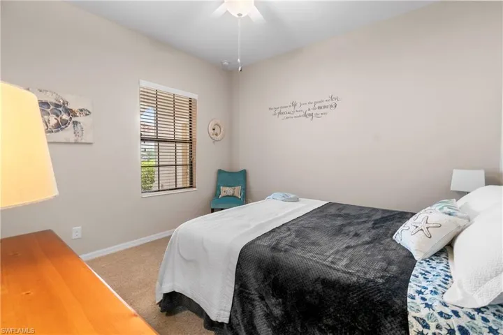 Carpeted bedroom featuring ceiling fan and baseboards