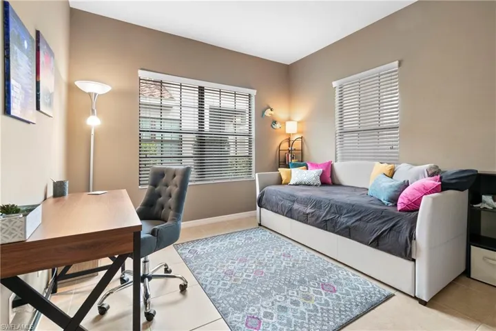 Bedroom featuring light tile patterned floors and baseboards