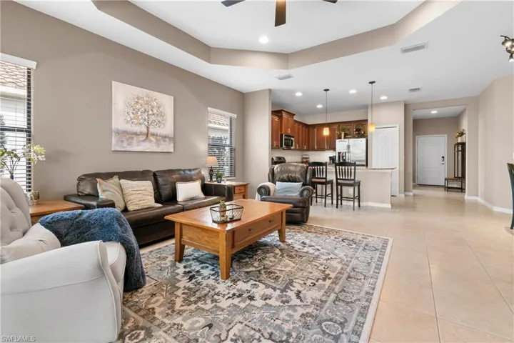 Living area featuring light tile patterned floors, recessed lighting, a ceiling fan, visible vents, and baseboards