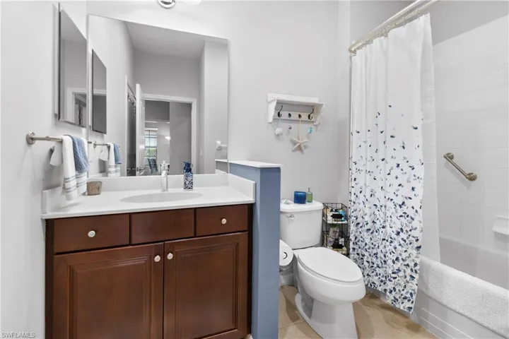 Bathroom with shower / tub combo, vanity, and toilet