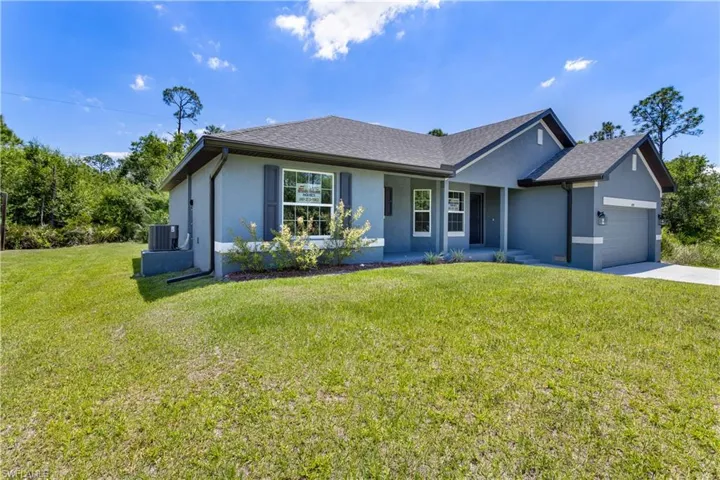 Single story home with a front yard, central AC unit, a garage, concrete driveway, and stucco siding