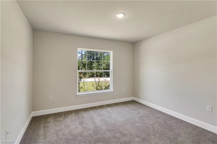Carpeted empty room with baseboards