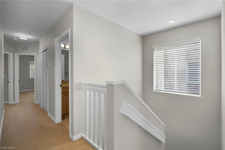 Hall with an upstairs landing and light carpet