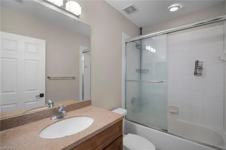 Bathroom featuring vanity and combined bath / shower with glass door