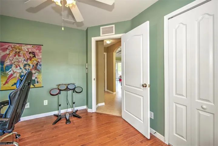 Home office with ceiling fan and light wood-type flooring