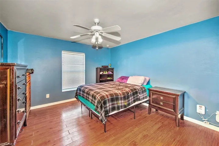 Bedroom with ceiling fan and wood-type flooring