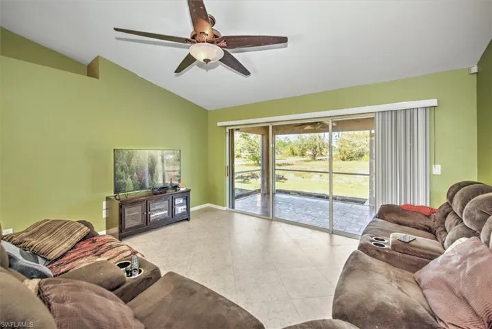 Living room featuring ceiling fan and vaulted ceiling