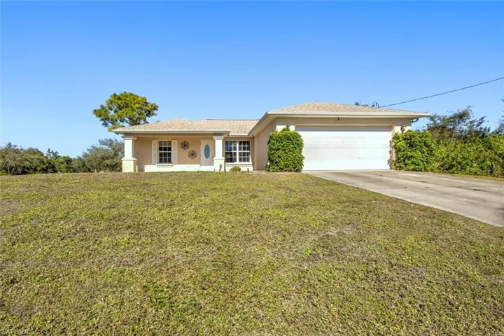 View of front of property featuring a front yard and a garage