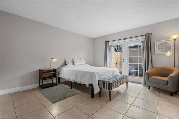 Bedroom with a textured ceiling and access to exterior