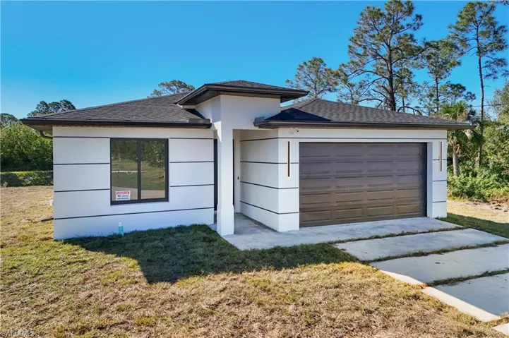 Contemporary single-story exterior featuring a dark asphalt shingle roof and white stucco siding with horizontal banding