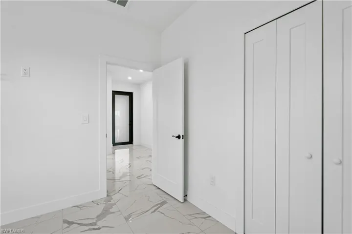Contemporary interior featuring white walls and a white paneled door