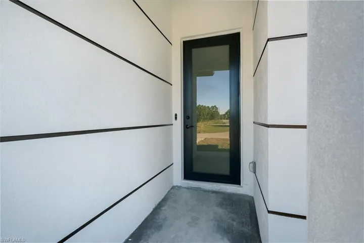 Modern exterior featuring white textured stucco with dark horizontal accent banding