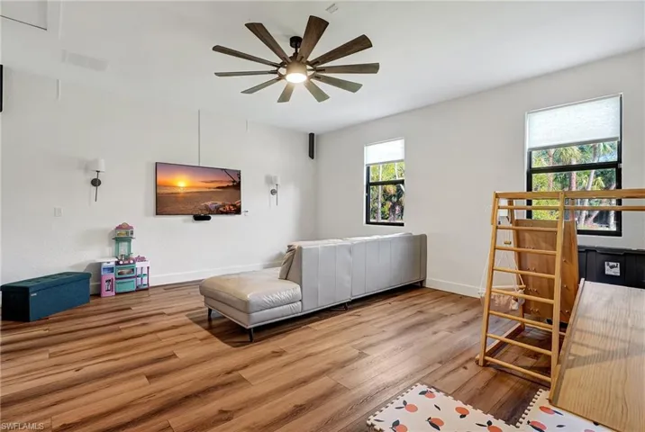 Living room with ceiling fan and light hardwood / wood-style floors