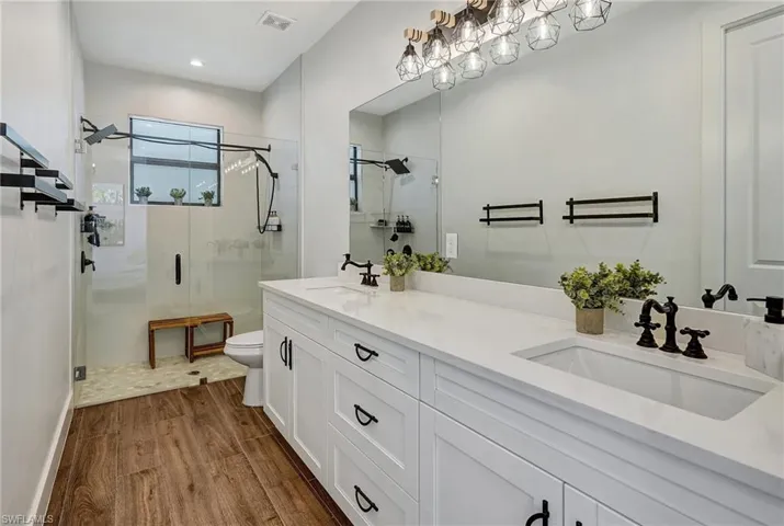 Bathroom featuring hardwood / wood-style floors, vanity, toilet, and walk in shower