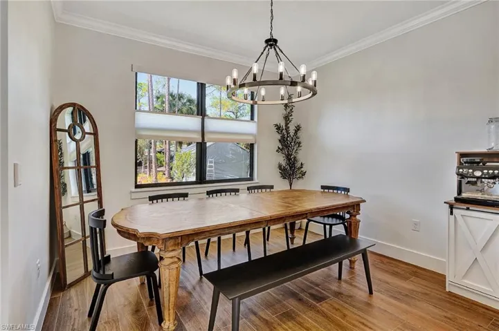 Dining area featuring light hardwood / wood-style floors, ornamental molding, and a chandelier