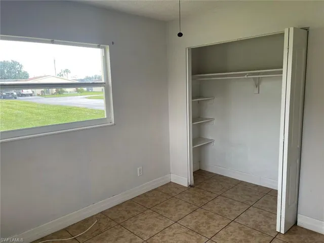 Unfurnished bedroom with a closet, light tile patterned floors, and a textured ceiling