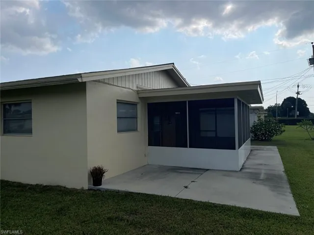 Back of property with a patio, a lanai, and a yard