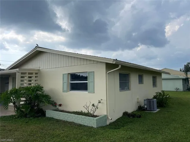 View of home's exterior featuring a yard and central air condition unit