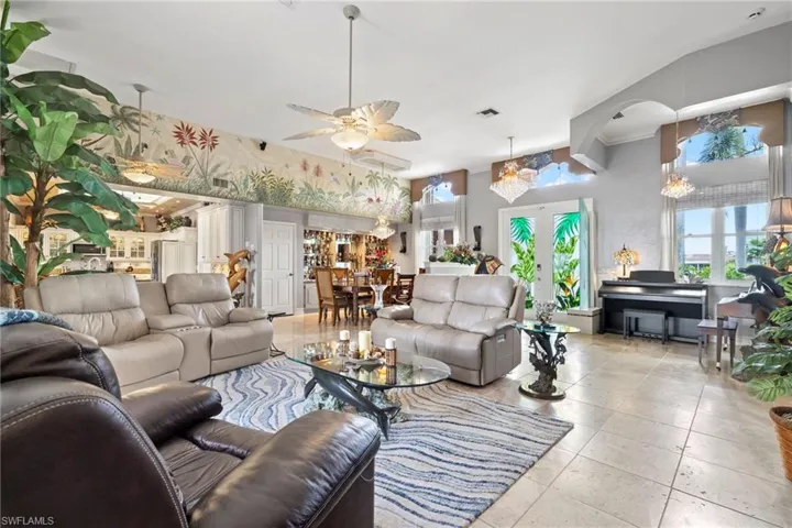 Tiled living room featuring ceiling fan with Swarovski crystal chandeliers