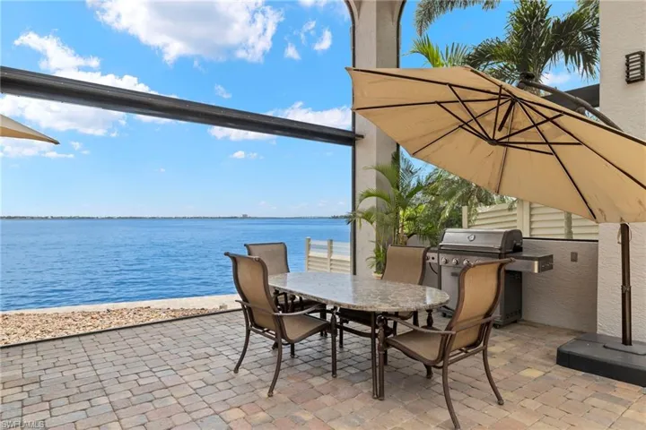 View of patio with a water view and grilling area