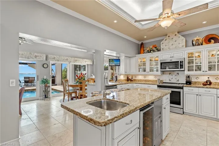 Kitchen featuring stainless steel appliances, a kitchen island with sink, crown molding, sink, and granite counters