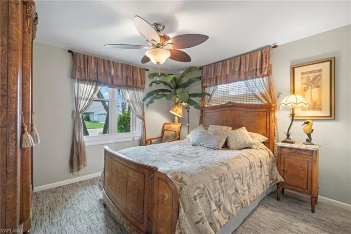 Carpeted bedroom featuring ceiling fan