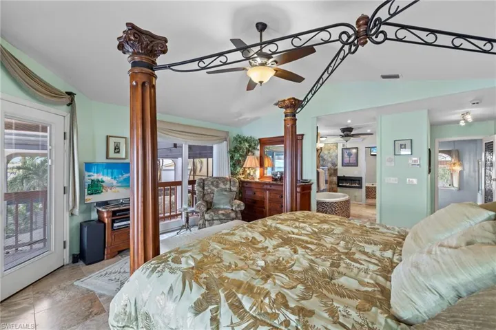 Bedroom with access to outside, cathedral ceiling, and ceiling fan