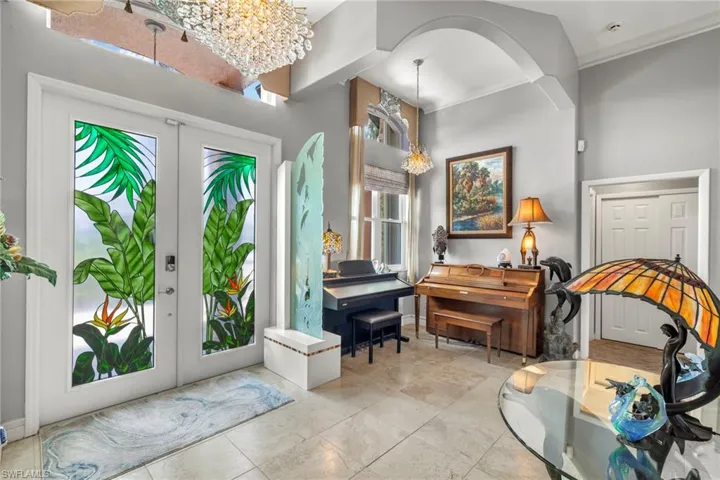 Entrance foyer with Swarovski crystal chandeliers, Custom stained glass french doors, and crown molding