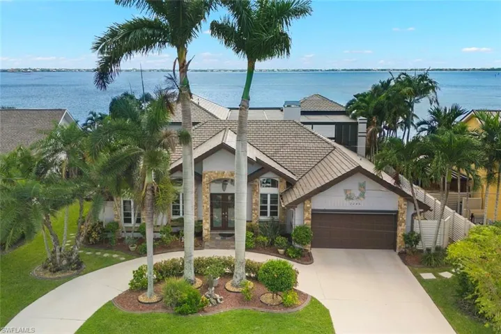 View of front of house featuring concrete driveway, a water view, a garage, and french doors