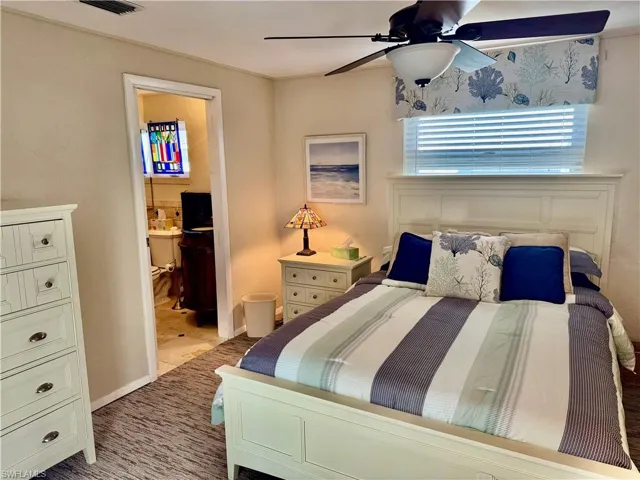 Bedroom featuring ensuite bath and ceiling fan