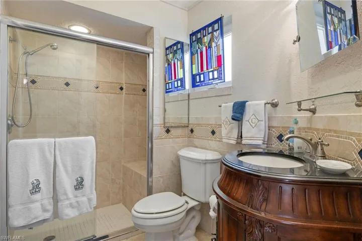 Bathroom featuring walk-in shower with frameless glass enclosure